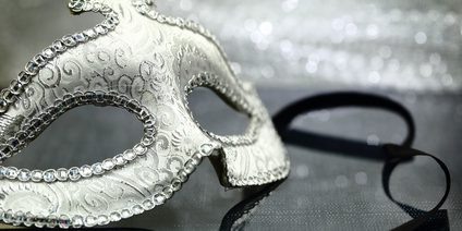 Vintage carnival mask in front of glittering background